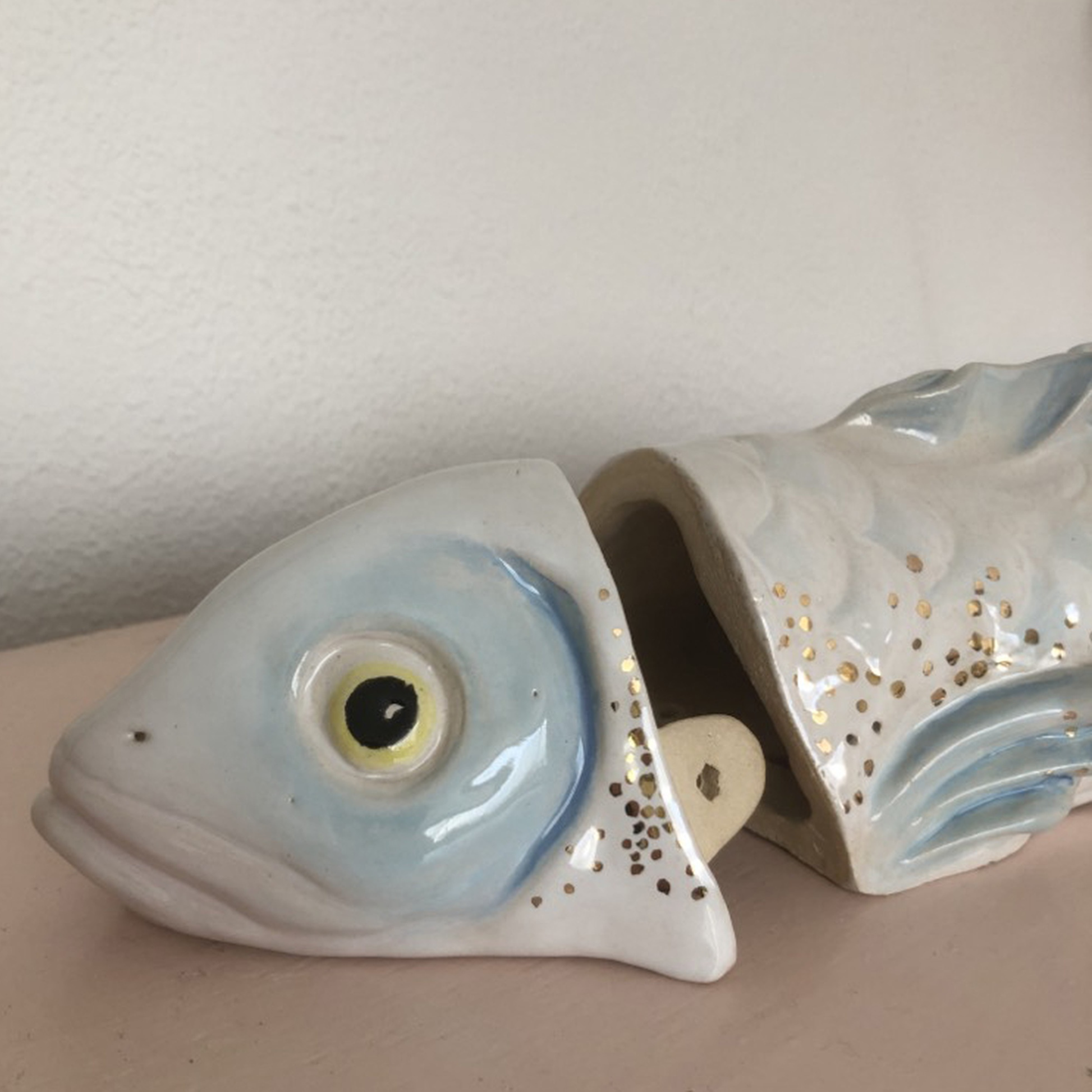 Close-up of the 24-carat gold accents on a handcrafted ceramic fish urn.