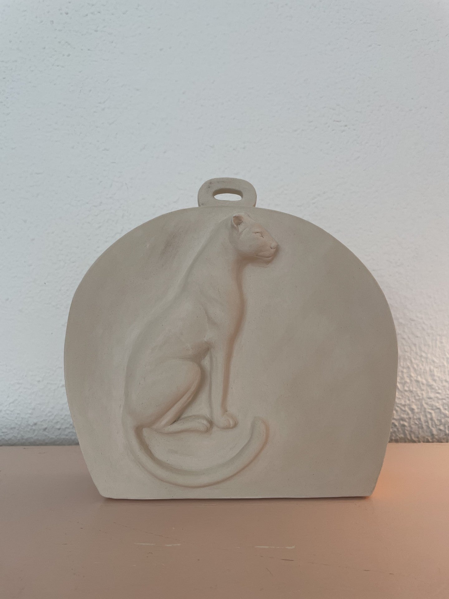 Voorbeeld van ongeglazuurde gedenkurn met luipaard in reliëf.