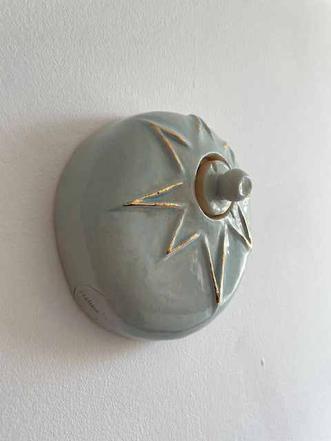 Handcrafted light blue ceramic mini angel urn with 24-carat gold details, suitable for wall mounting.