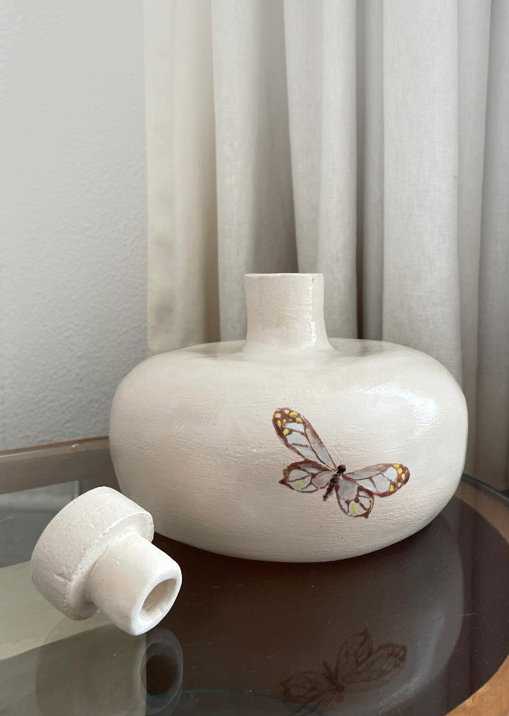Close-up of the handcrafted butterfly design on a ceramic memorial urn.