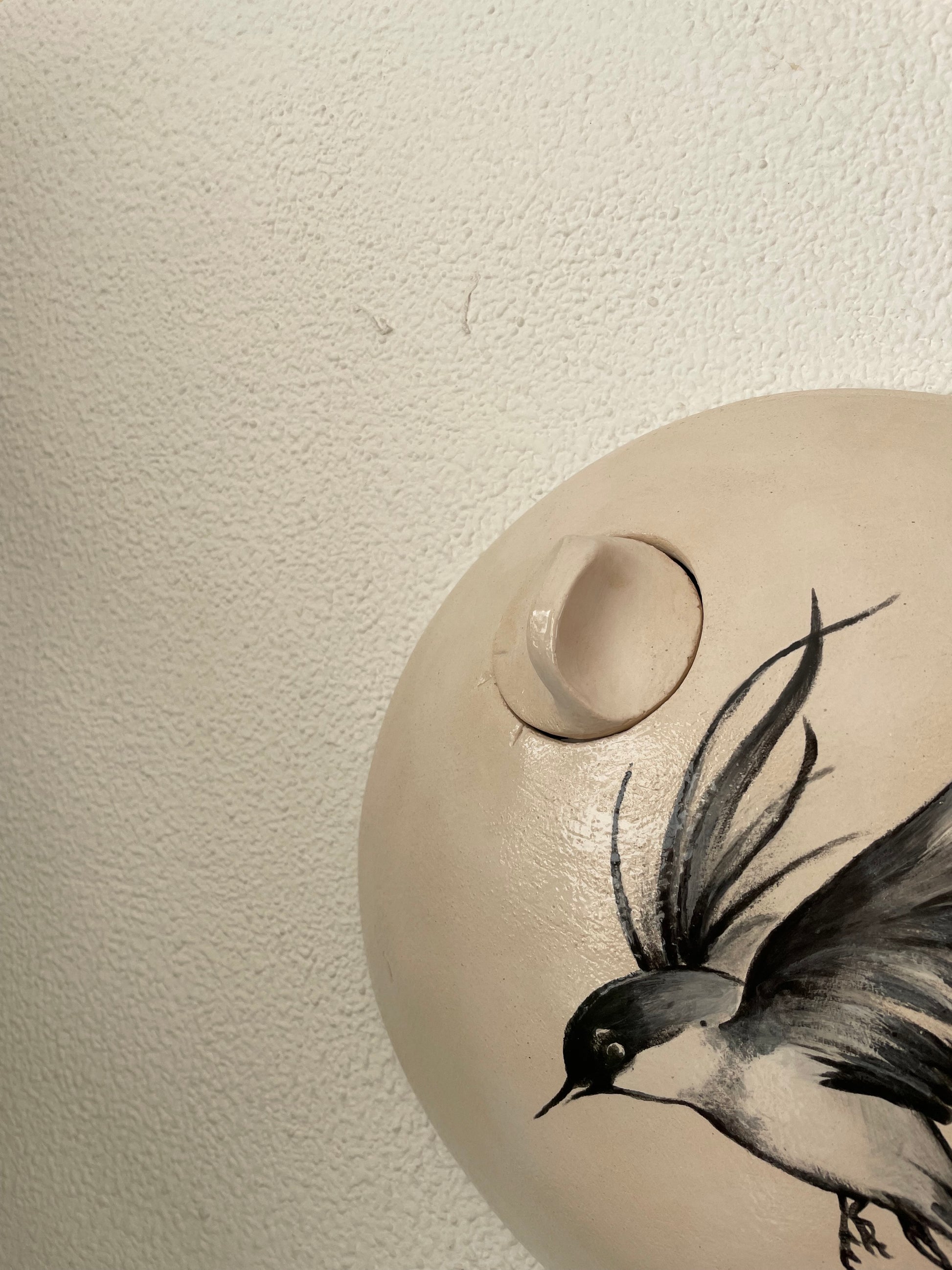 Off-white ronde gedenkurn met vogel.