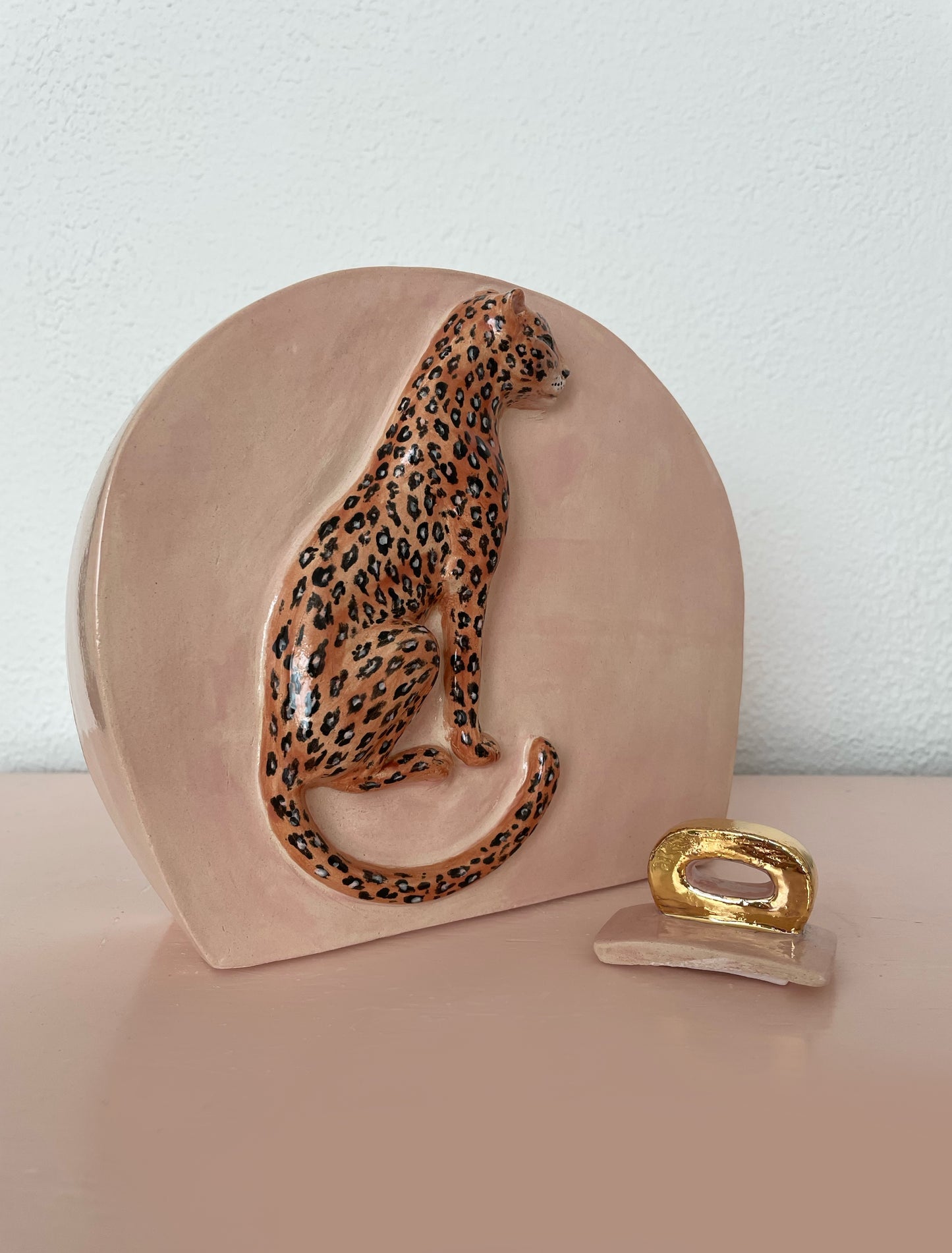 Close-up van unieke roze urn met wild dier en gouden deksel.