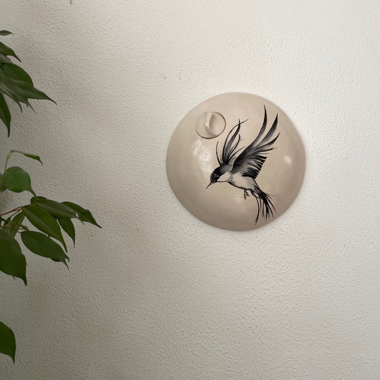 Handgemaakte natuurlijke off-white keramische urn met een handgeschilderde vogel.